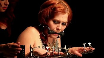 Play Gagged redhead babe in bondage device gets spanked